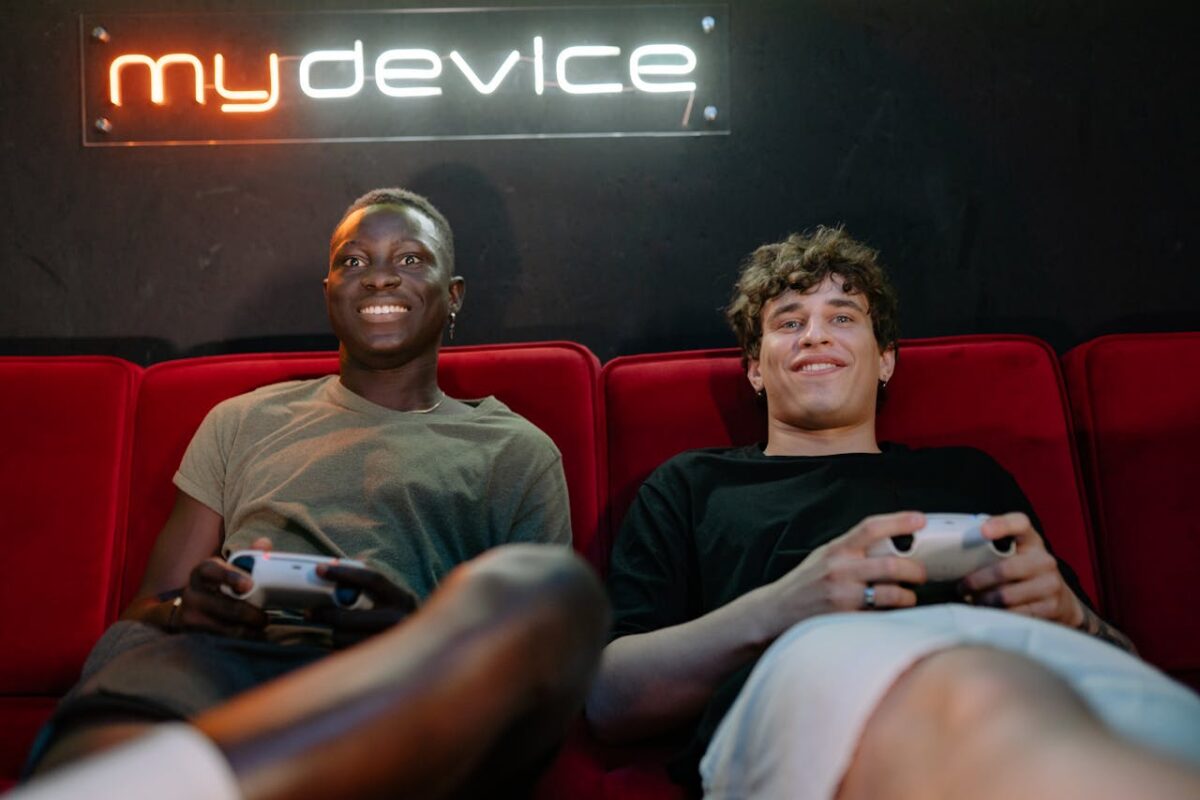 Two friends enjoying video games on a cozy couch setting.